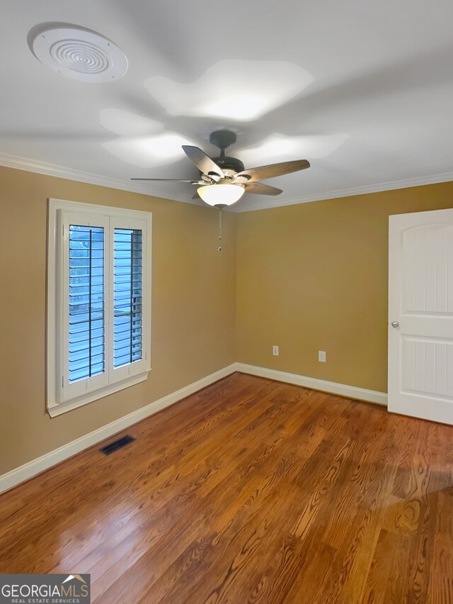 unfurnished room with ceiling fan, ornamental molding, and wood-type flooring