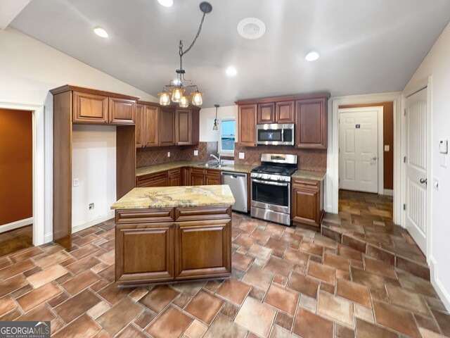 kitchen with light stone counters, pendant lighting, lofted ceiling, tasteful backsplash, and appliances with stainless steel finishes