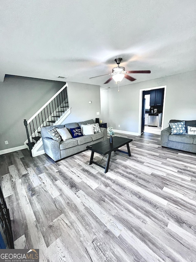 living room with ceiling fan, hardwood / wood-style floors, and a textured ceiling