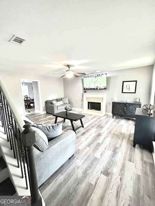 living room featuring wood-type flooring and ceiling fan