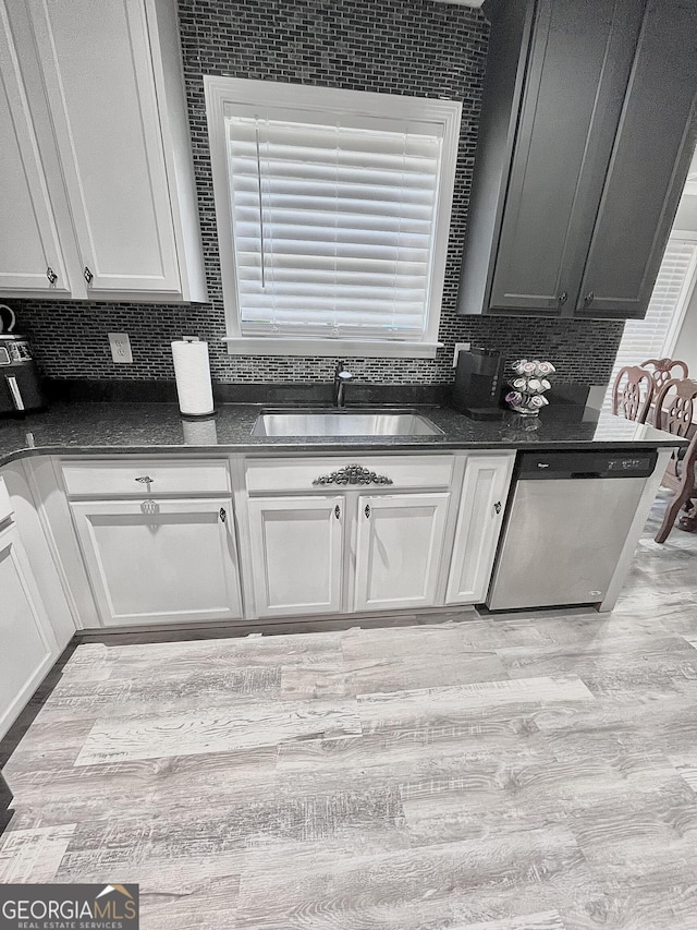 kitchen featuring light hardwood / wood-style floors, white cabinets, sink, and stainless steel dishwasher