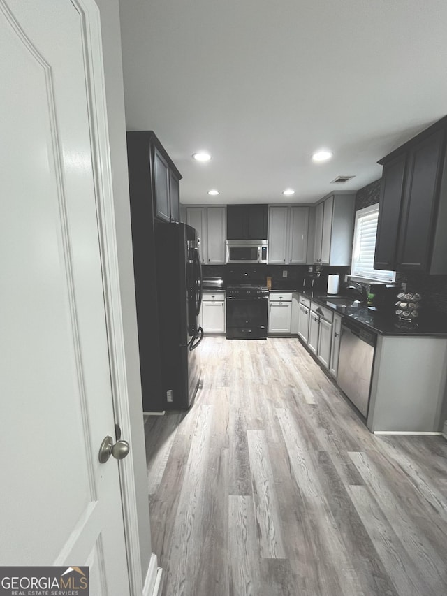 kitchen featuring black appliances, decorative backsplash, sink, light hardwood / wood-style floors, and gray cabinets