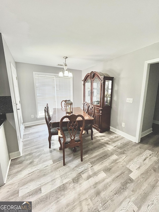 dining area with an inviting chandelier and light wood-type flooring