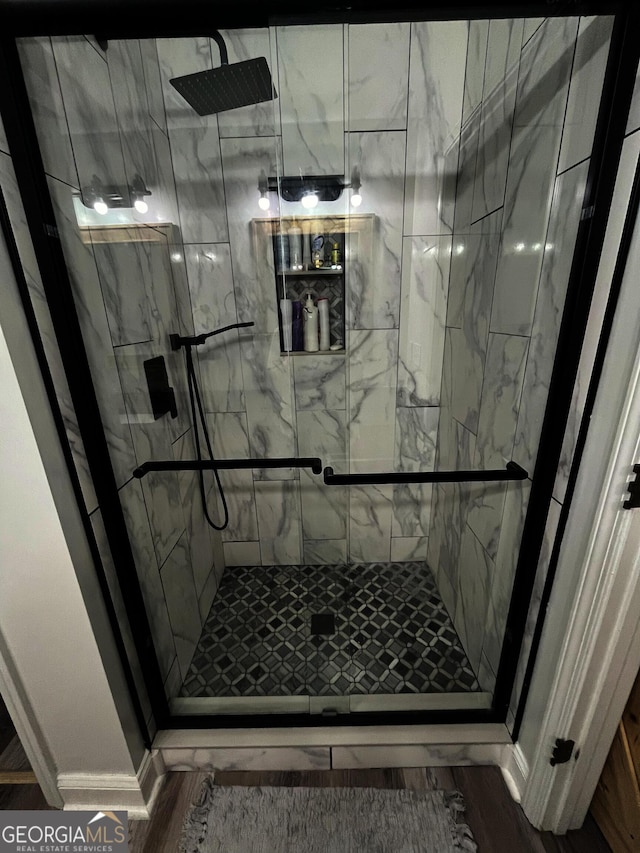 bathroom featuring wood-type flooring and tiled shower