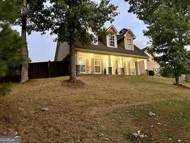 cape cod-style house featuring a front lawn