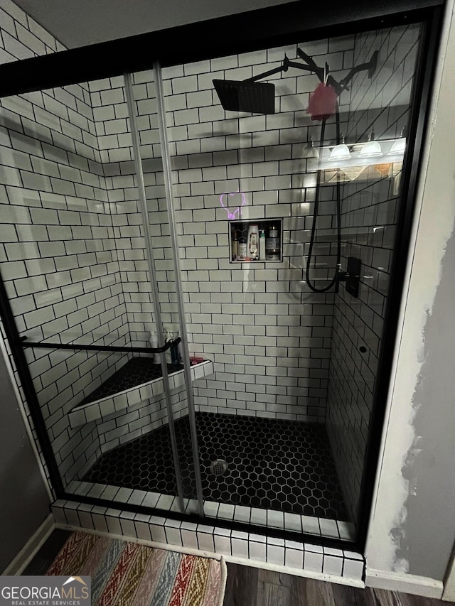 bathroom featuring hardwood / wood-style floors and a shower with shower door