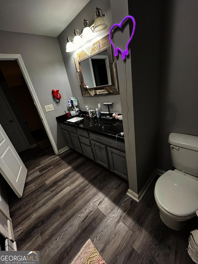 bathroom featuring vanity, toilet, and wood-type flooring