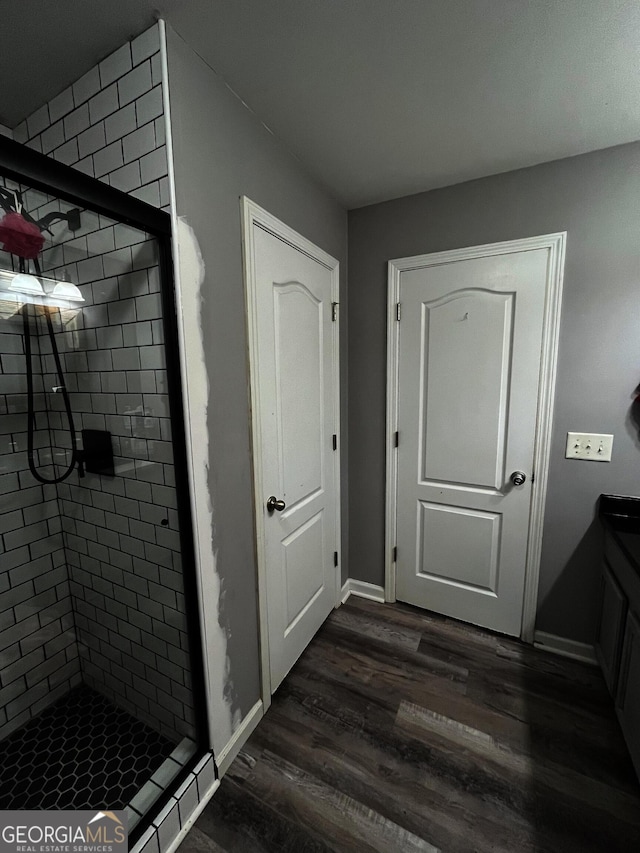 bathroom featuring walk in shower, vanity, and hardwood / wood-style floors