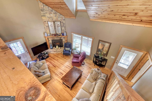 living room with wooden ceiling, wood-type flooring, a fireplace, and high vaulted ceiling