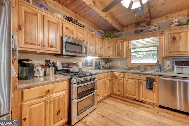 kitchen with beamed ceiling, stainless steel appliances, light hardwood / wood-style flooring, ceiling fan, and sink