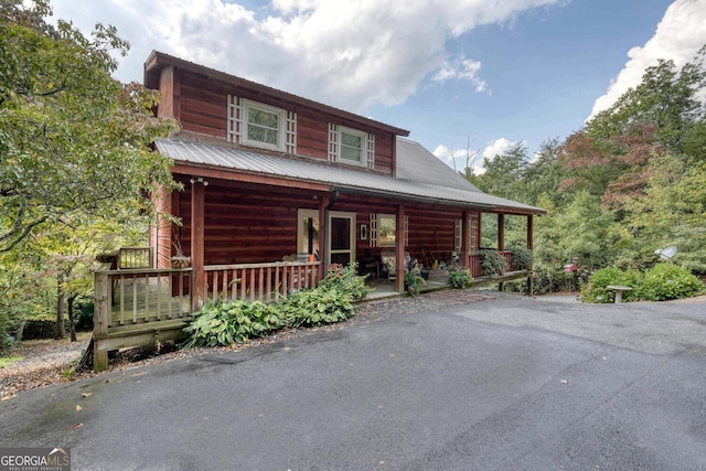 log cabin featuring covered porch