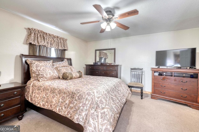 carpeted bedroom with ceiling fan and a textured ceiling