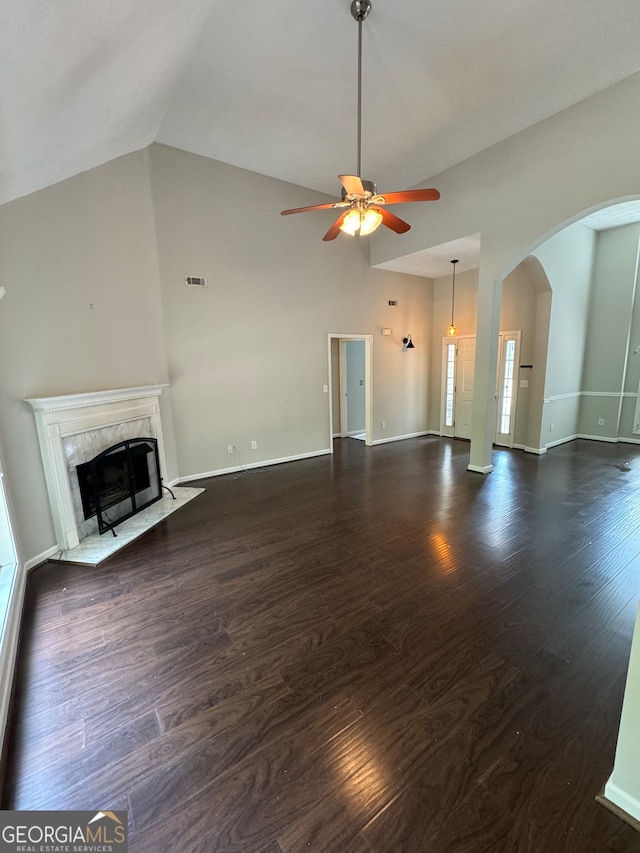 unfurnished living room featuring a premium fireplace, vaulted ceiling, ceiling fan, and dark hardwood / wood-style floors