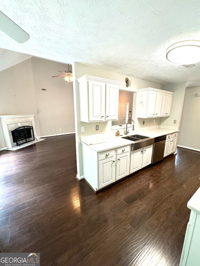 kitchen with dishwasher, dark hardwood / wood-style floors, sink, a premium fireplace, and ceiling fan