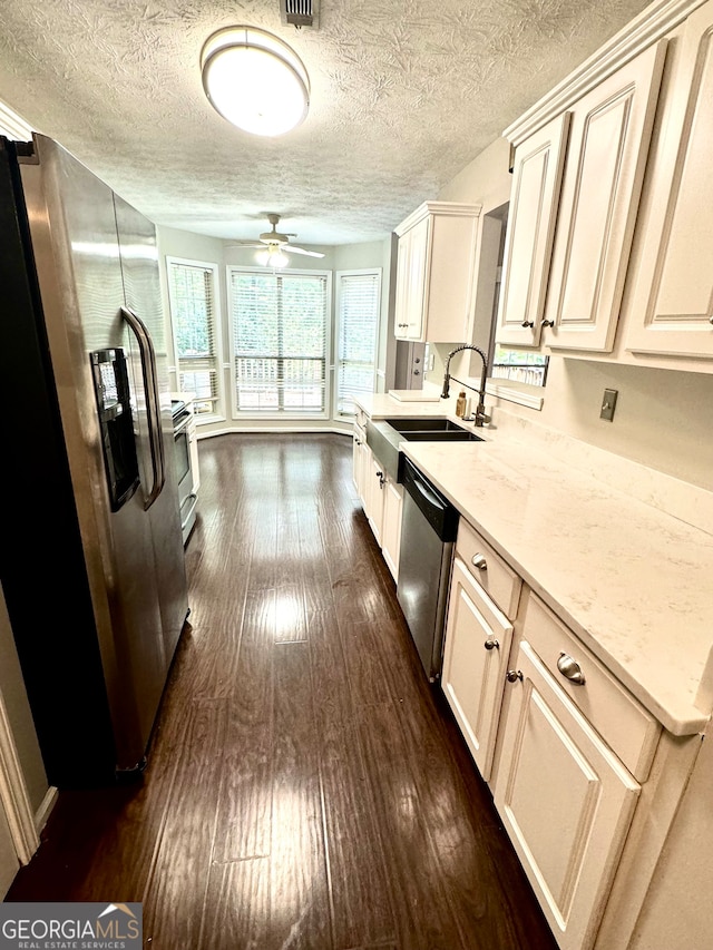 kitchen featuring dark hardwood / wood-style floors, sink, appliances with stainless steel finishes, light stone countertops, and ceiling fan