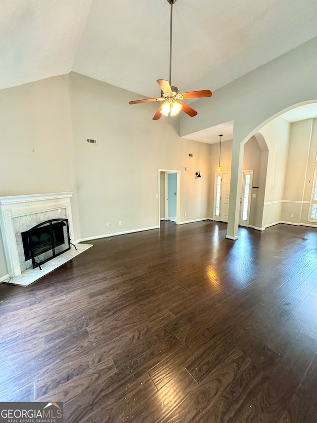 unfurnished living room featuring high vaulted ceiling, ceiling fan, a fireplace, and dark wood-type flooring