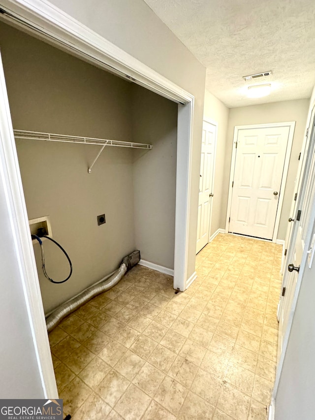 laundry room featuring hookup for an electric dryer, a textured ceiling, and hookup for a washing machine