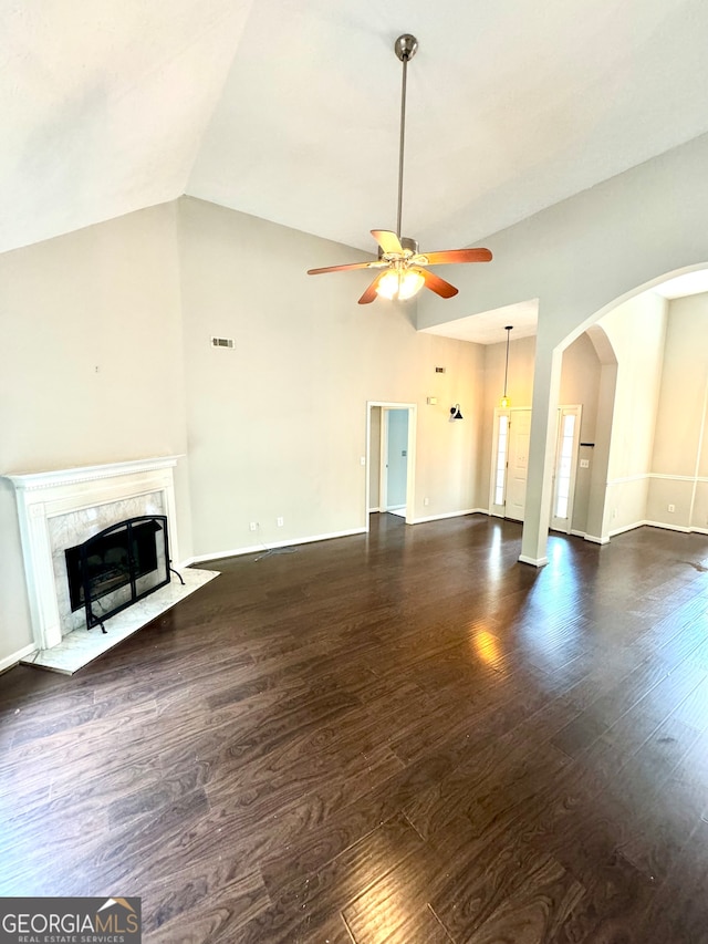 unfurnished living room featuring high vaulted ceiling, a high end fireplace, ceiling fan, and dark wood-type flooring