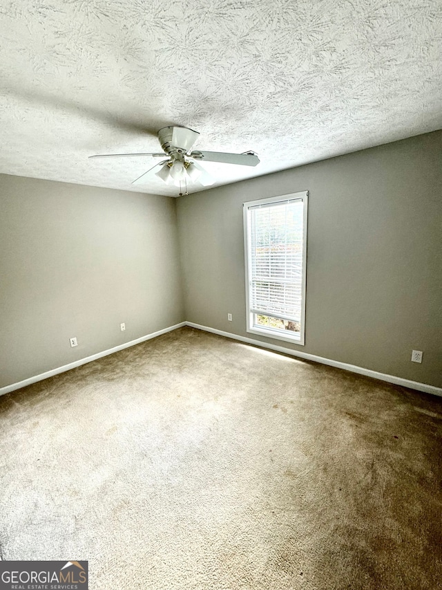 spare room with ceiling fan, carpet floors, and a textured ceiling