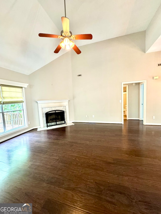 unfurnished living room featuring a high end fireplace, dark hardwood / wood-style floors, ceiling fan, and high vaulted ceiling