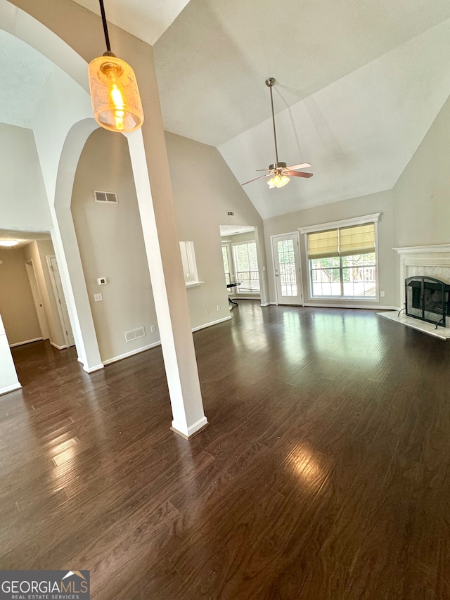 unfurnished living room with ceiling fan, dark hardwood / wood-style floors, and high vaulted ceiling