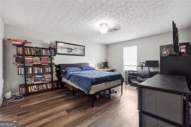 bedroom with a textured ceiling and hardwood / wood-style floors