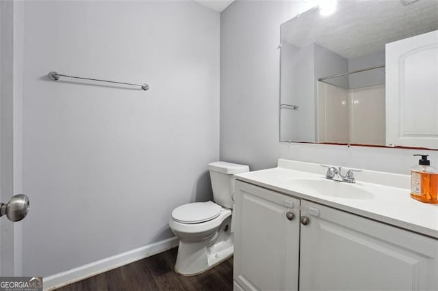 bathroom featuring toilet, a shower, hardwood / wood-style floors, and vanity