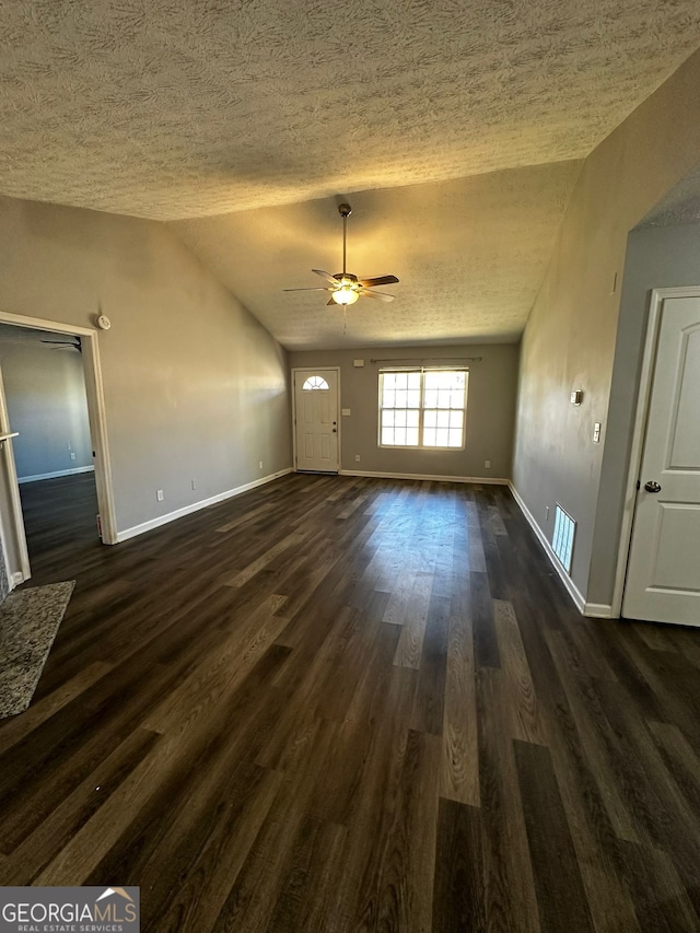 unfurnished living room with ceiling fan, a textured ceiling, dark hardwood / wood-style floors, and lofted ceiling