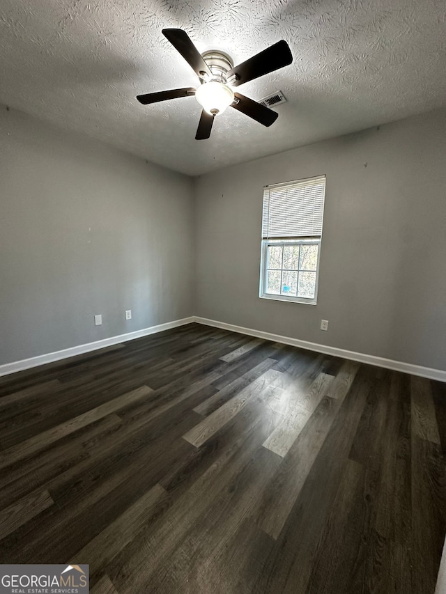 unfurnished room with ceiling fan, dark wood-type flooring, and a textured ceiling