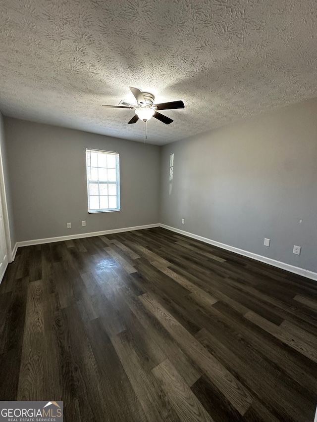 unfurnished room with ceiling fan, dark hardwood / wood-style flooring, and a textured ceiling