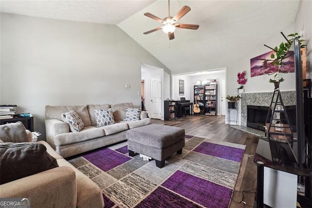 living room featuring ceiling fan, a high end fireplace, lofted ceiling, and wood-type flooring