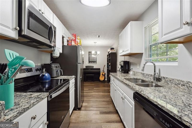 kitchen featuring sink, white cabinets, stainless steel appliances, and light wood-type flooring