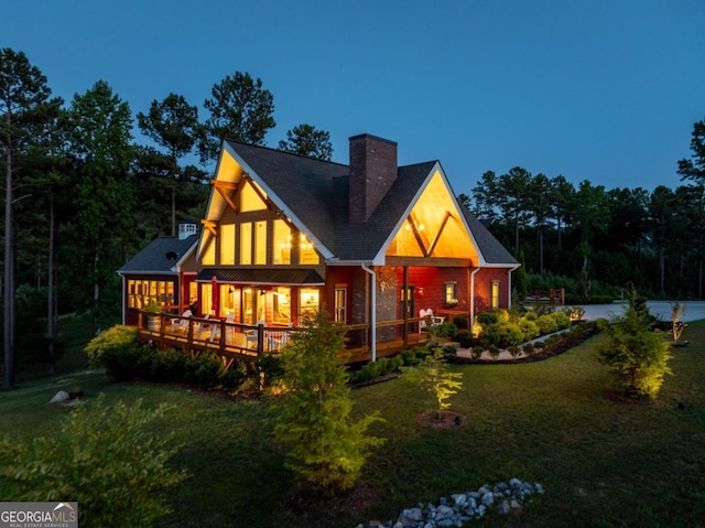 back of property featuring a deck and a yard