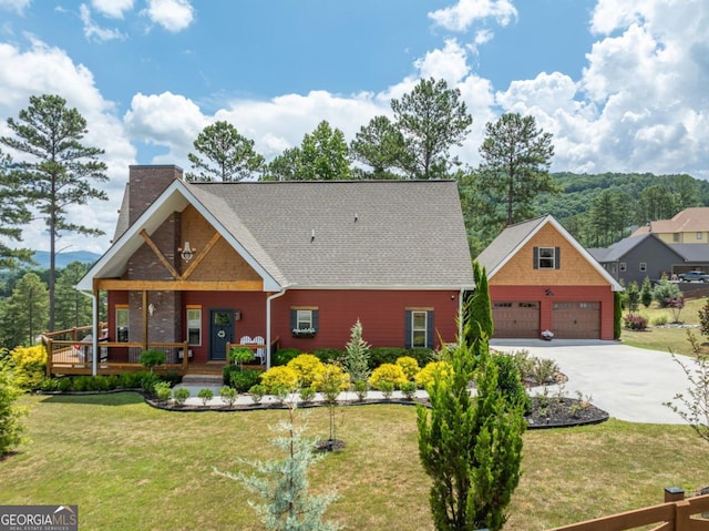 view of front of property featuring a front lawn, covered porch, and a garage