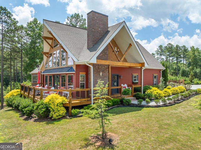 back of house featuring a lawn and a wooden deck