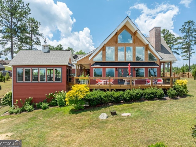 back of property with a deck and a yard