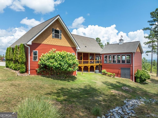 rear view of house featuring a yard