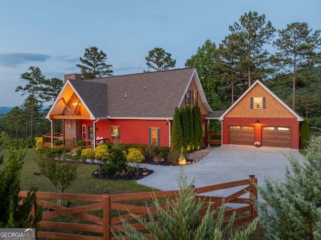 view of front of property featuring an outdoor structure, a garage, and covered porch