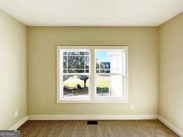 carpeted empty room featuring baseboards