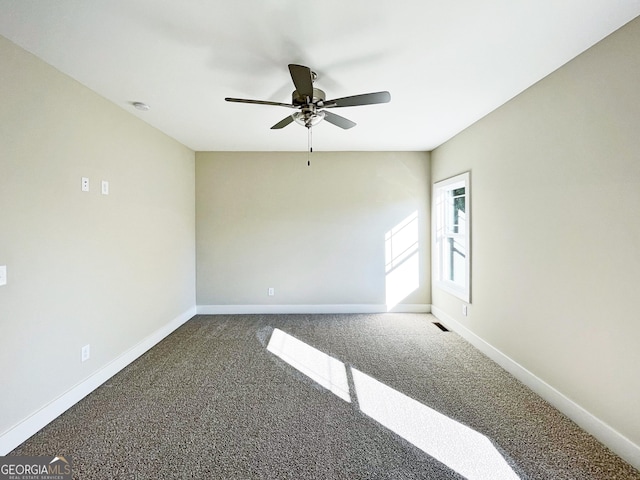 unfurnished room with visible vents, carpet flooring, a ceiling fan, and baseboards