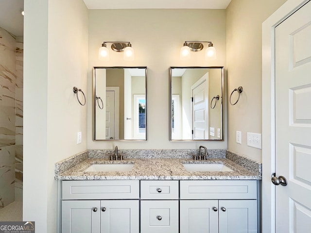 full bath featuring a sink, a tile shower, and double vanity