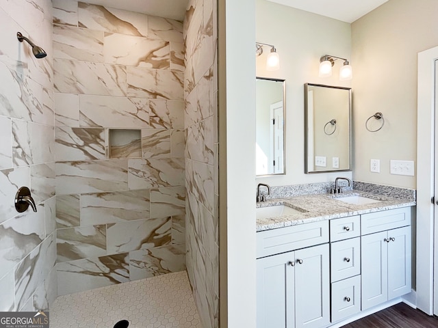 bathroom featuring a tile shower, wood-type flooring, and vanity