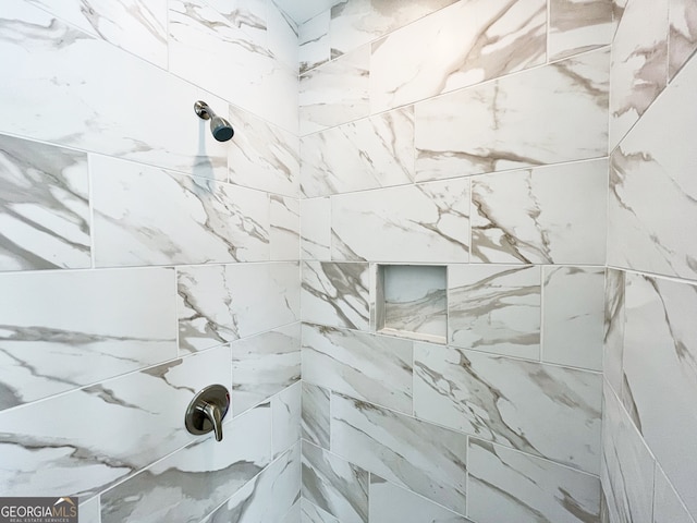 interior details featuring a tile shower