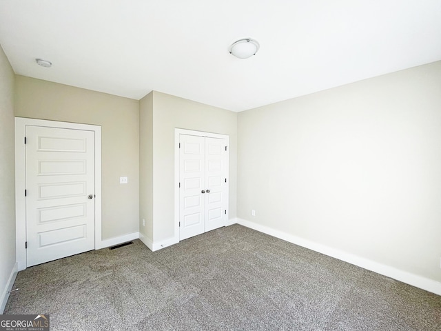 unfurnished bedroom featuring carpet floors, a closet, visible vents, and baseboards