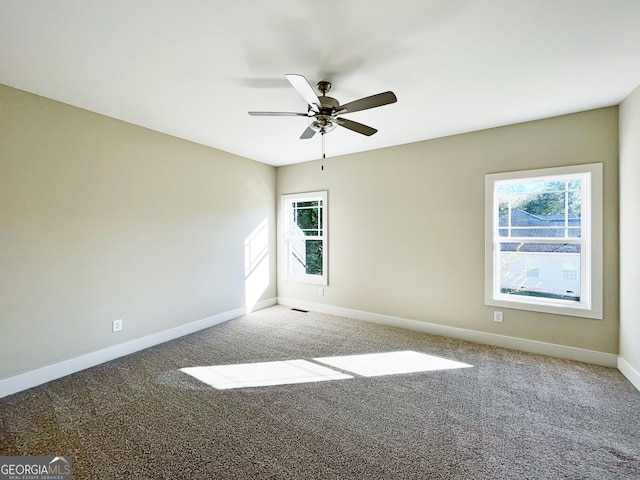 spare room with a ceiling fan, carpet, and baseboards