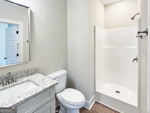 bathroom with vanity, hardwood / wood-style flooring, toilet, and walk in shower