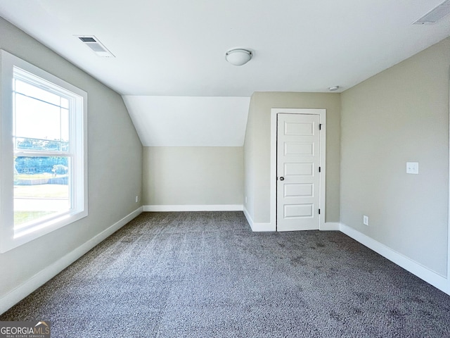 additional living space with carpet floors, lofted ceiling, visible vents, and baseboards