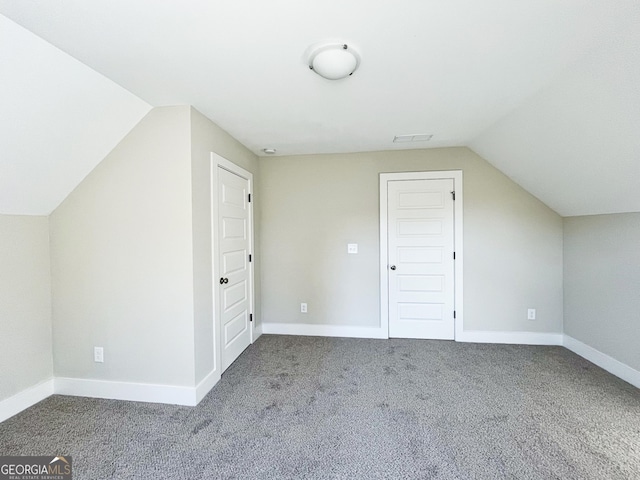 additional living space featuring visible vents, baseboards, vaulted ceiling, and carpet flooring