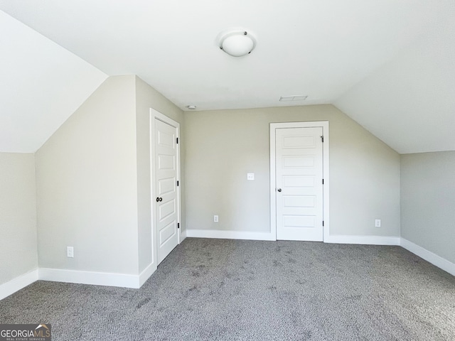 bonus room with vaulted ceiling and carpet floors