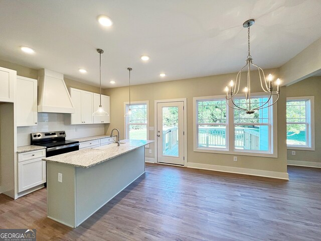 unfurnished living room featuring ceiling fan with notable chandelier, hardwood / wood-style flooring, plenty of natural light, and a fireplace